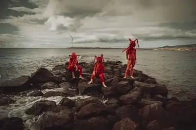 Las tres científicas de La Langosta sobre rocas junto al mar.